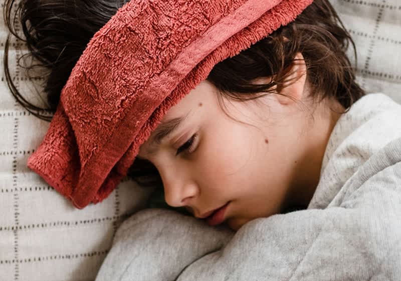Bambino a letto con raffreddore