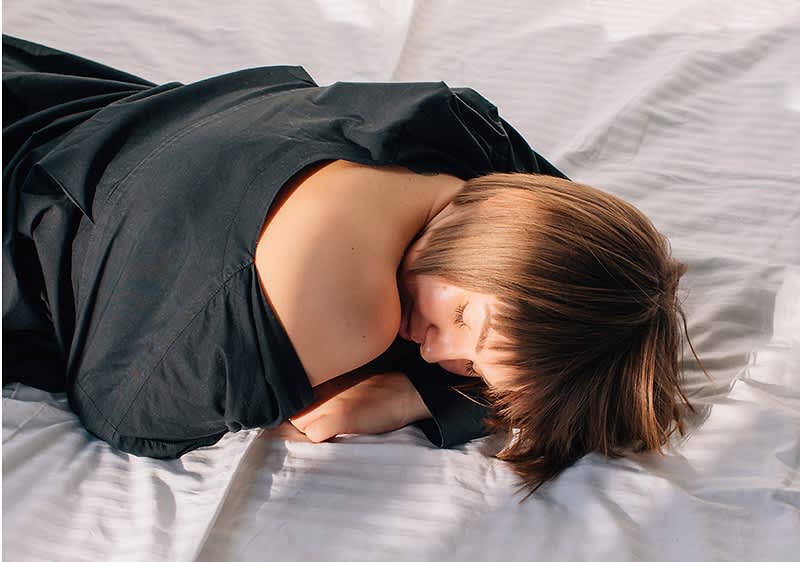 Donna distesa sul letto che si riposa