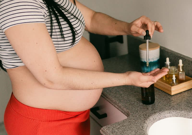 Donna si mette olio sulla pancia