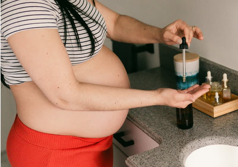 Donna si mette olio sulla pancia