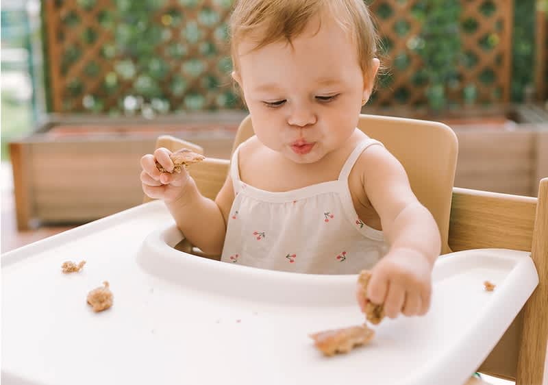 babè mangia seduto su un seggiolone