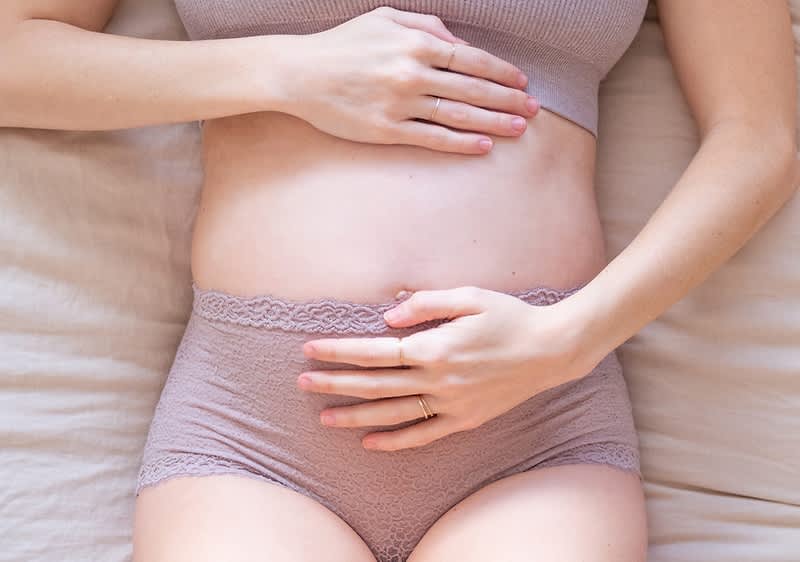 Donna incinta che si tocca la pancia