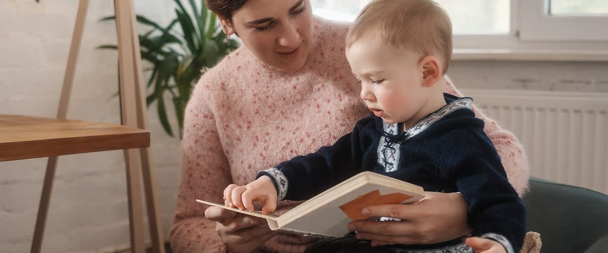 bambino legge un libro con la mamma