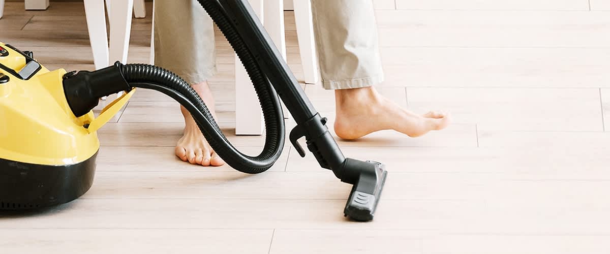 persona passa l'aspirapolvere sul pavimento