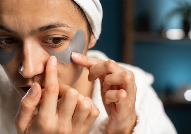 Donna applica i patch occhi