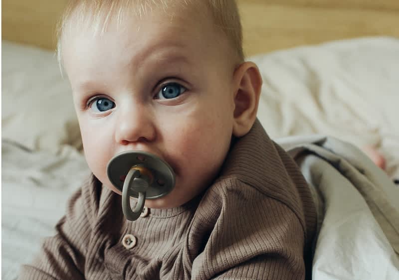 bebè con ciuccio color verde oliva