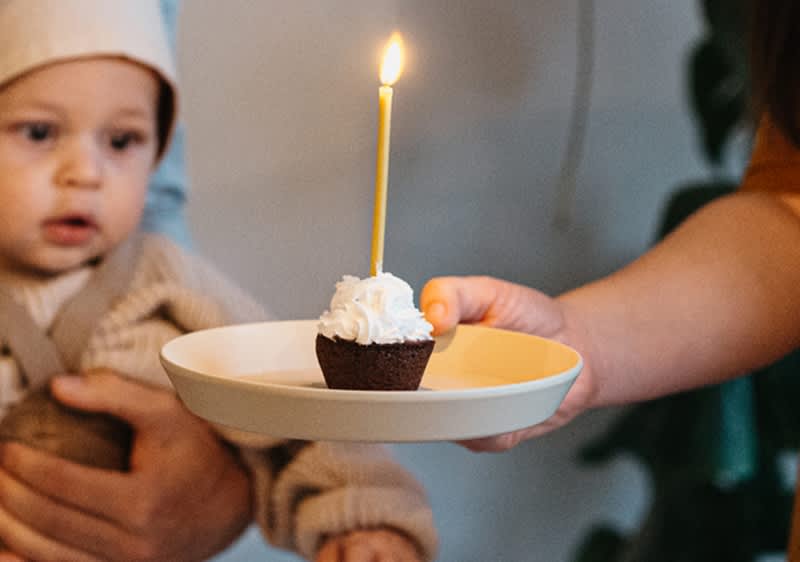 bebè festeggia il suo primo compleanno con un muffin con candela
