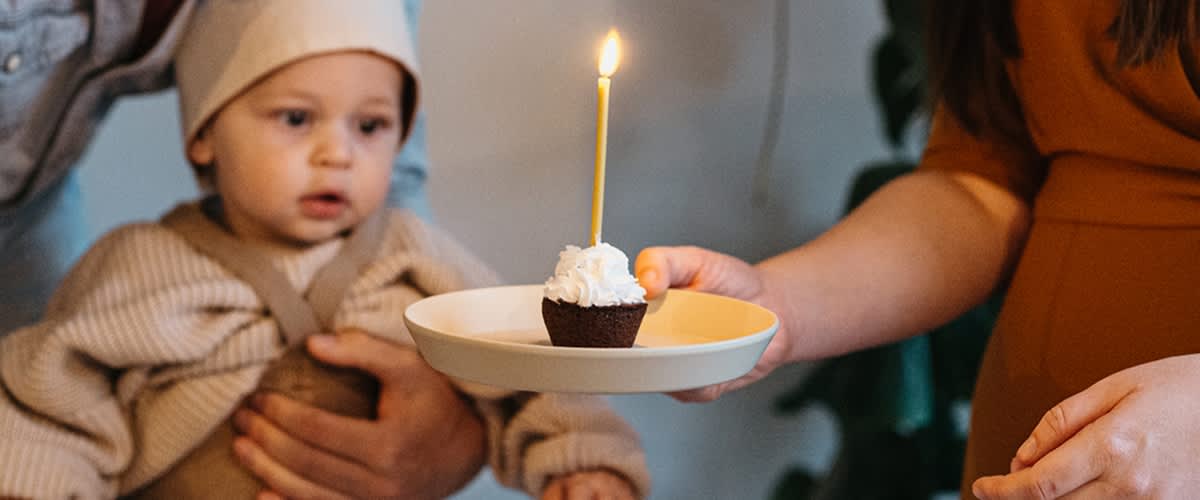 bebè festeggia il suo primo compleanno con un muffin con candela