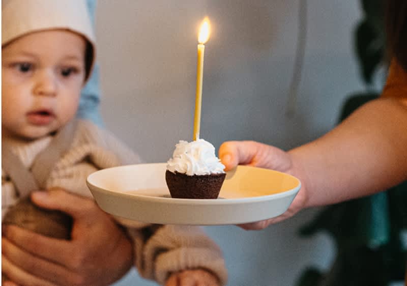 bebè festeggia il suo primo compleanno con un muffin con candela