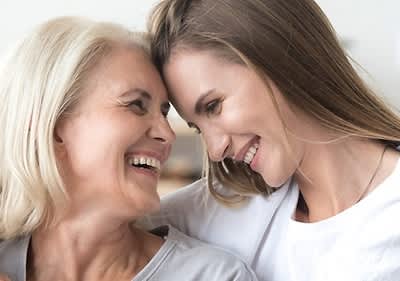 Due donne abbracciate con capelli biondi e castani