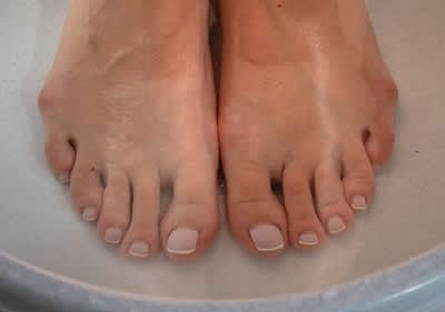 Piedi immersi in acqua per pediluvio