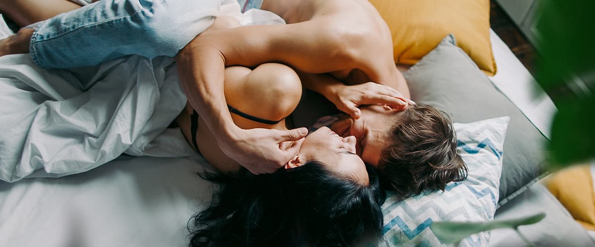 uomo e donna su un letto e si coccolano