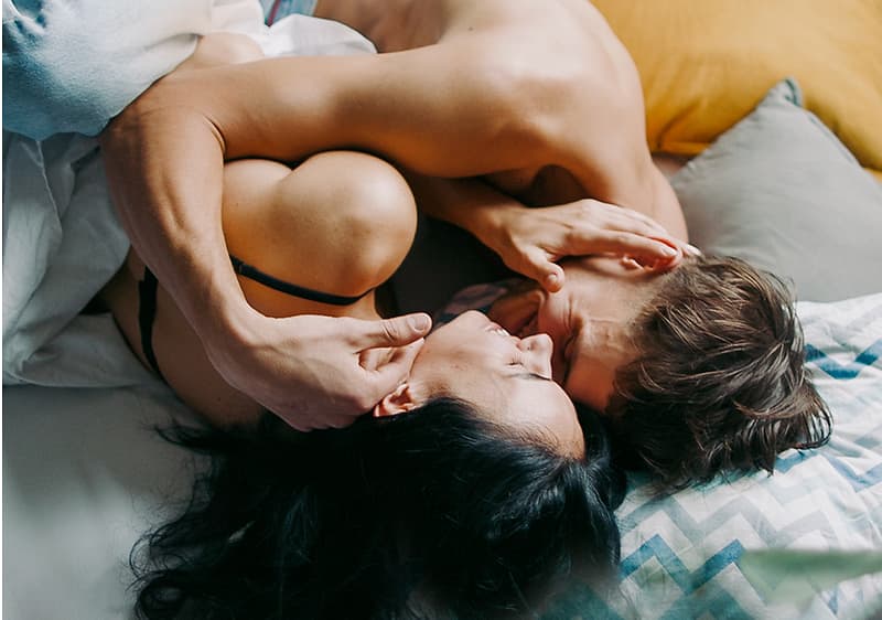 uomo e donna su un letto e si coccolano