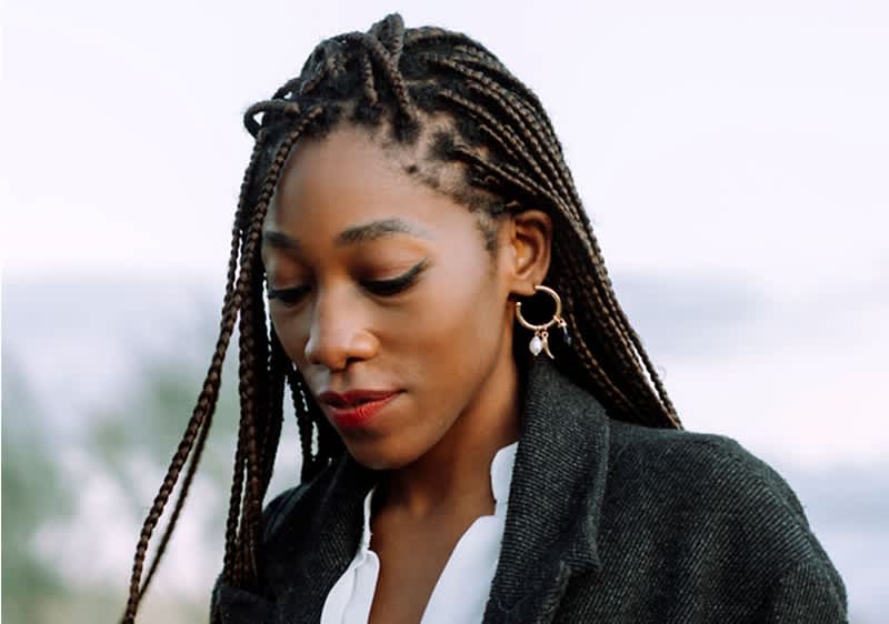 Donna con treccine afro e orecchini dorati