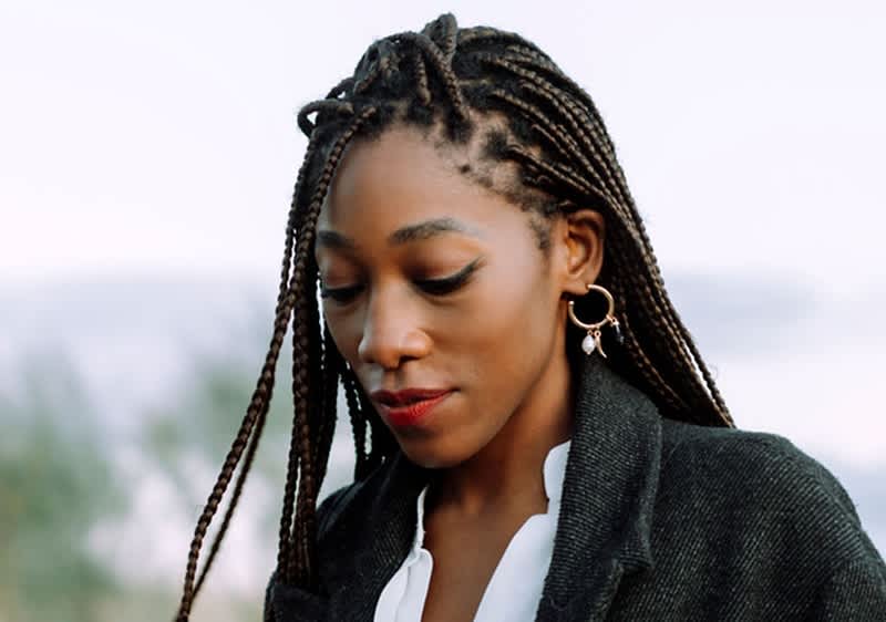 Donna con treccine afro e orecchini dorati