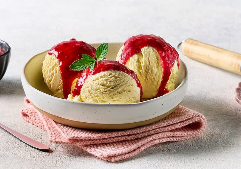 Gelato vegano alla vaniglia con salsa di frutti rossi e foglia di menta