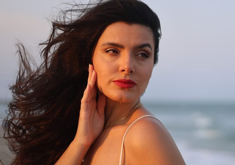 Donna con capelli mossi al vento sulla spiaggia