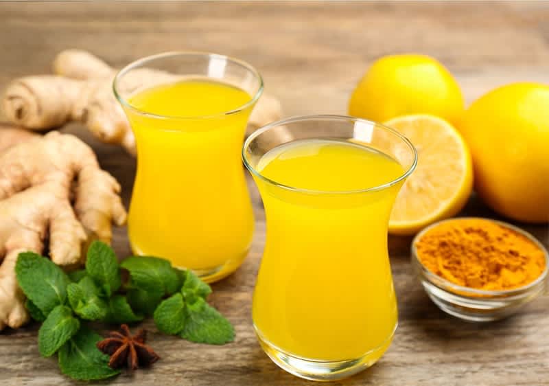 Bevanda allo zenzero con limoni e curcuma su tavolo di legno