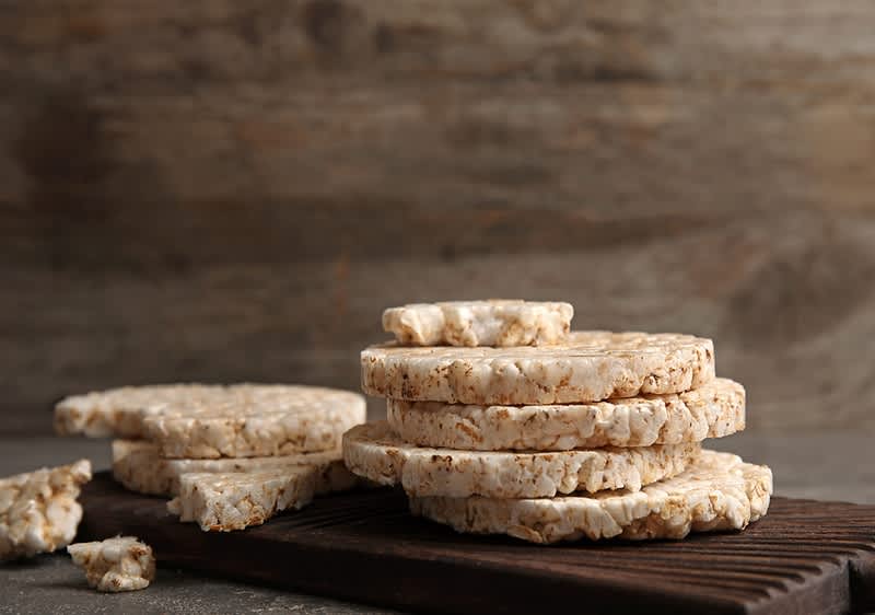 Gallette di riso impilate su un tagliere di legno