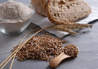 Farro con pane e farina su tavolo grigio