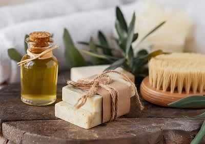 Sapone naturale con olio essenziale e spazzola su tavola di legno