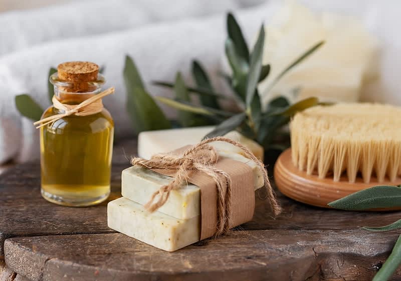 Sapone naturale con olio essenziale e spazzola su tavola di legno