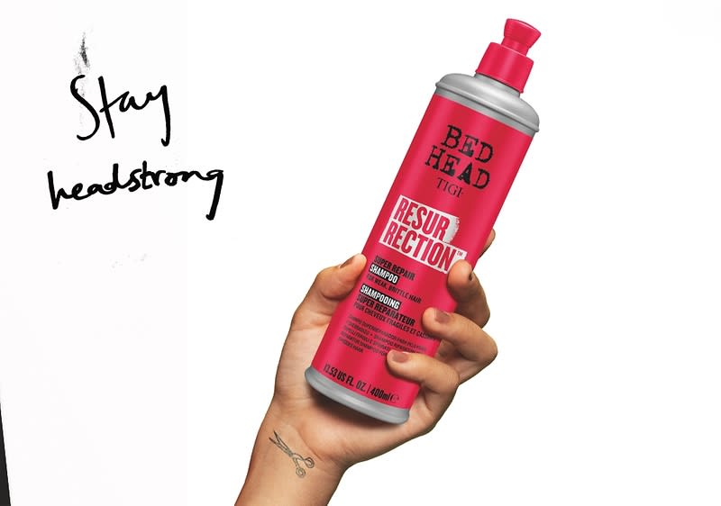 Prodotti per capelli Bed Head in flaconi colorati su sfondo bianco e rosso