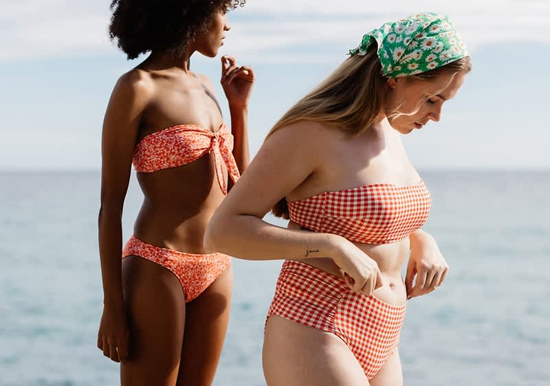 Donne in bikini sulla spiaggia con mare sullo sfondo