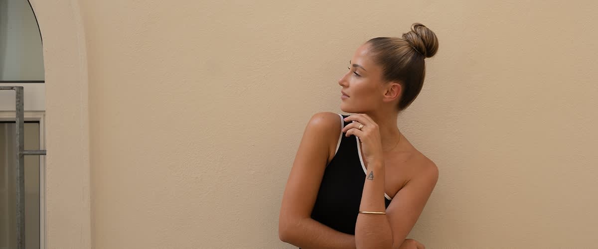 Donna con sleek bun e tatuaggio triangolo sul braccio