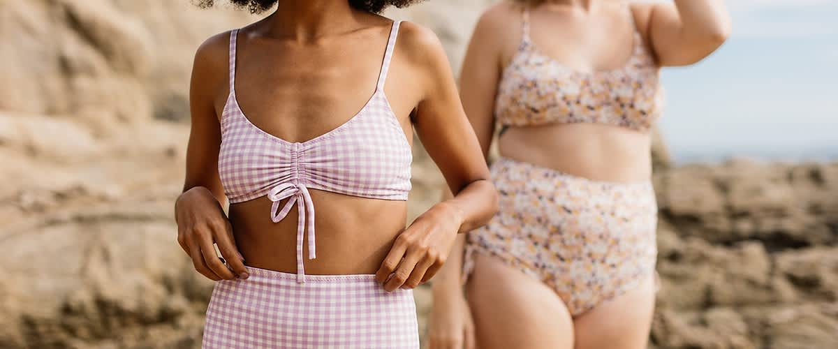 Due donne indossano costumi da bagno a quadretti e a motivo floreale