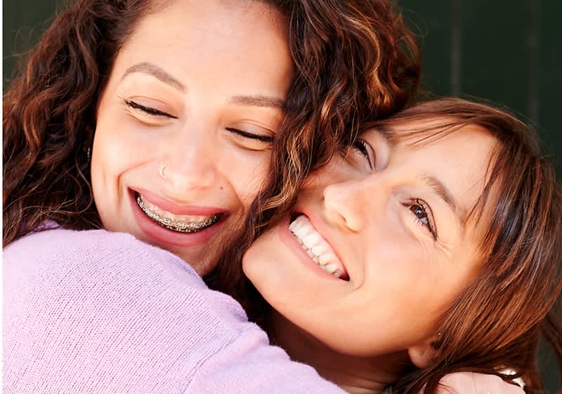 Due donne si abbracciano e sorridono