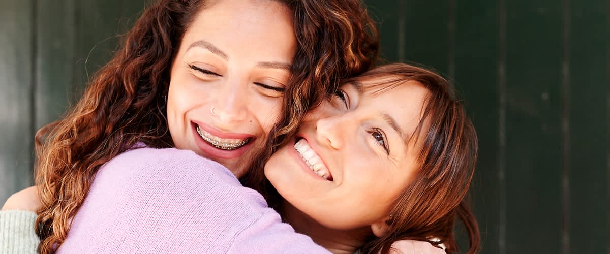 Due donne si abbracciano e sorridono