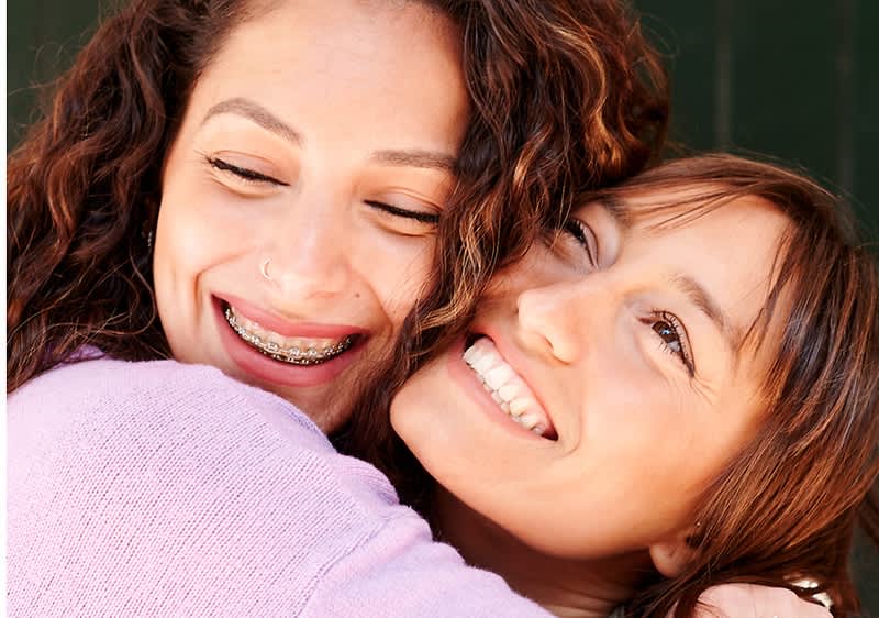 Due donne si abbracciano e sorridono