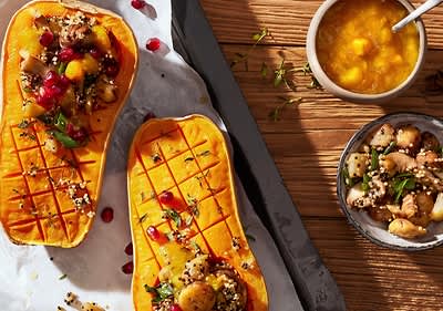 Zucca arrosto ripiena di quinoa e melograno su tavola di legno
