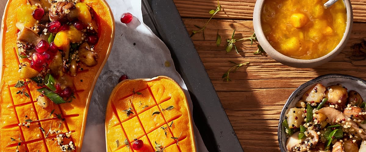 Zucca arrosto ripiena di quinoa e melograno su tavola di legno
