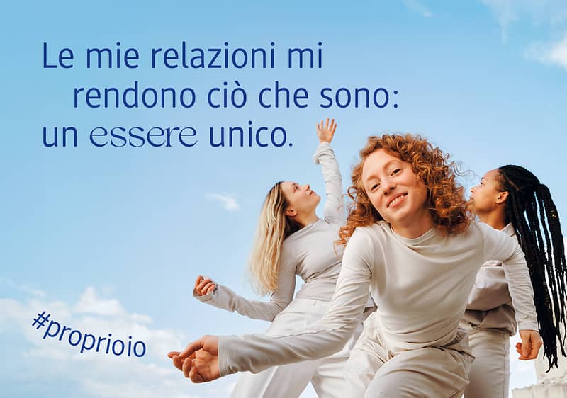Tre persone danzano sotto il cielo azzurro con testo motivazionale Le mie relazioni mi rendono ciò che sono: un essere unico.