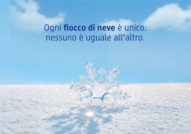 Fiocco di neve unico su distesa di neve con cielo azzurro con testo Ogni fiocco di neve è unico: nessuno è uguale all'altro.
