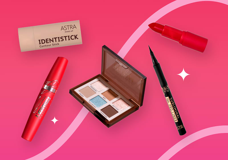 Prodotti make-up a marchio Astra su sfondo rosa: rossetto, mascara, palette ombretti, eyeliner, contour stick