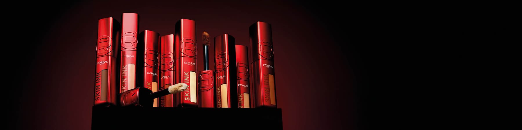 Correttori L'Oreal Skin Ink in confezioni rosse nelle diverse tonalità su sfondo nero