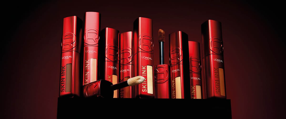 Correttori L'Oreal Skin Ink in confezioni rosse nelle diverse tonalità su sfondo nero