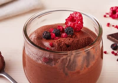 Mousse al cioccolato con frutti di bosco in bicchiere di vetro