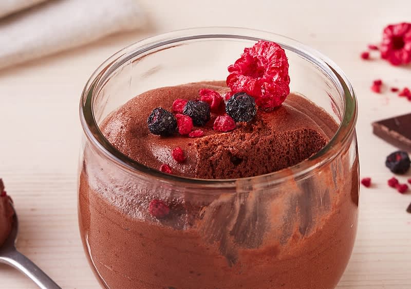Mousse al cioccolato con frutti di bosco in bicchiere di vetro