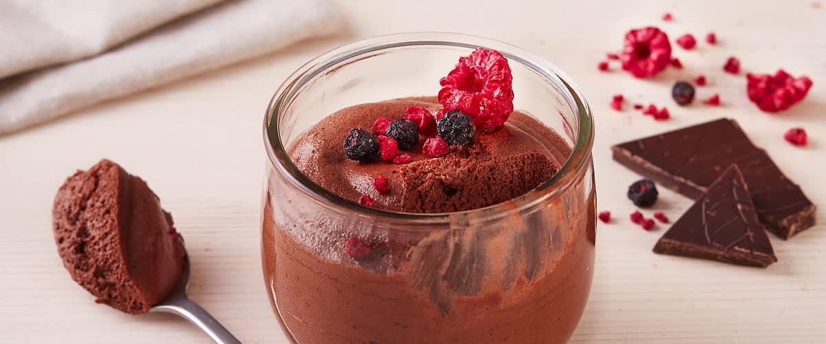 Mousse al cioccolato con frutti di bosco in bicchiere di vetro