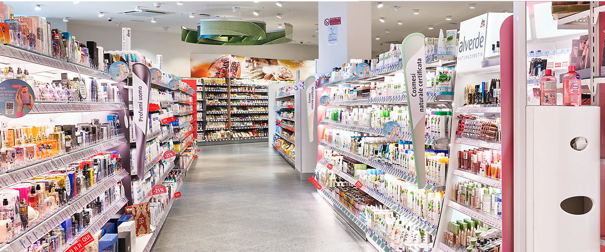 Interno di un punto vendita dm con scaffali pieni di cosmetici e prodotti di bellezza