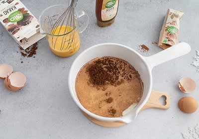Preparazione di un dolce con cacao e uova su un piano di lavoro