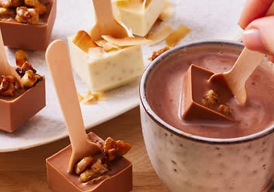 Cioccolata calda con cubetti di cioccolato e cucchiai di legno