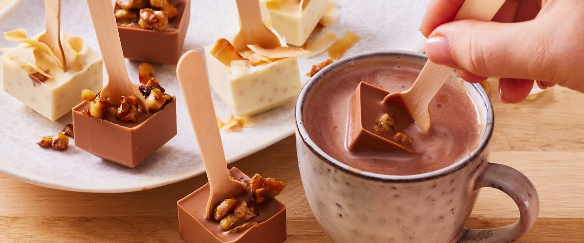 Cioccolata calda con cubetti di cioccolato e cucchiai di legno