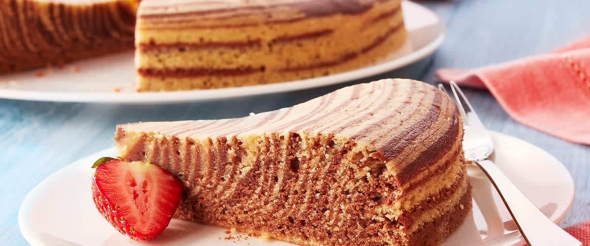 Torta zebrata vegana su piatto bianco con fragola