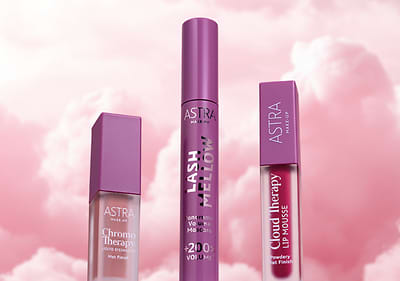 Cosmetici Astra con mascara e rossetti della linea Cloud Fairy su sfondo nuvoloso rosa