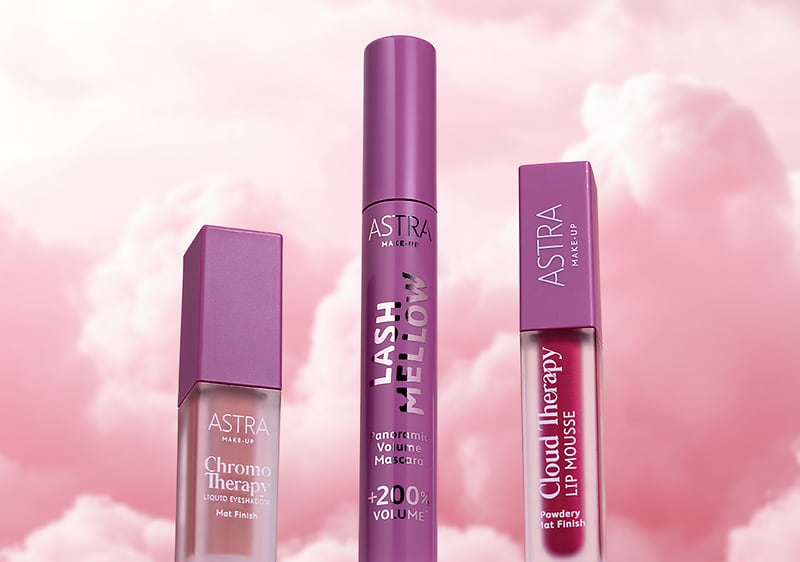Cosmetici Astra con mascara e rossetti della linea Cloud Fairy su sfondo nuvoloso rosa